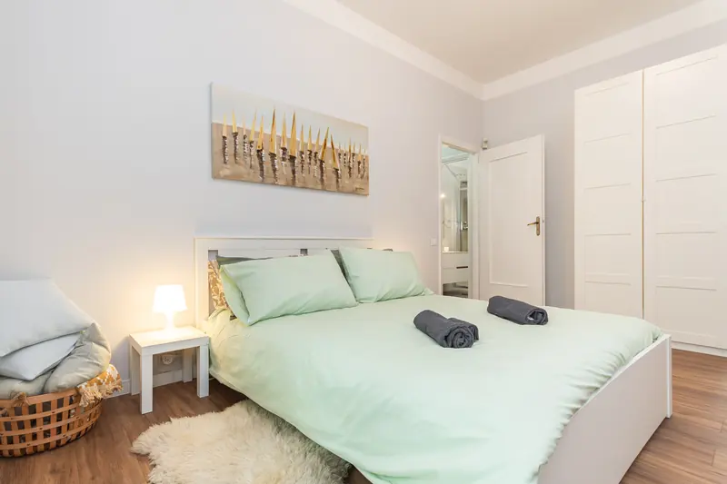 Camera con lenzuola verde menta e quadro con barche a vela: appartamento in affitto breve a Oregina, Genova gestito da Immobirent, 32.951 € incassati in un anno