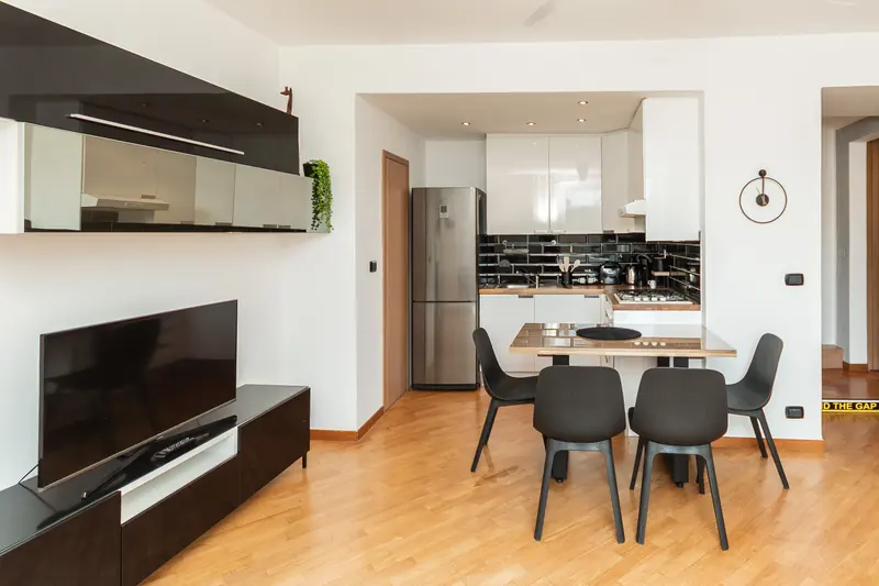 Soggiorno con cucina a vista in un appartamento gestito da Immobirent